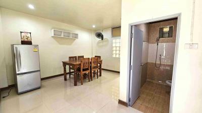 Spacious kitchen with dining table and adjacent bathroom