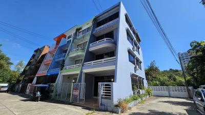 Exterior view of a multi-story residential building with balconies and outdoor parking