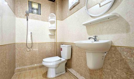 Modern tiled bathroom with shower, toilet, and sink