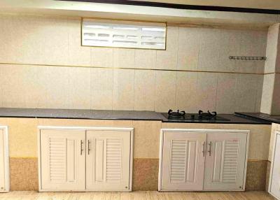 Compact kitchen with gas stove and ample storage cabinets