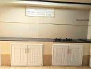 Compact kitchen with gas stove and ample storage cabinets