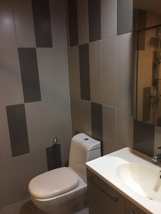 Modern tiled bathroom with toilet and sink