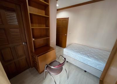 Cozy bedroom with built-in wooden wardrobe and single bed