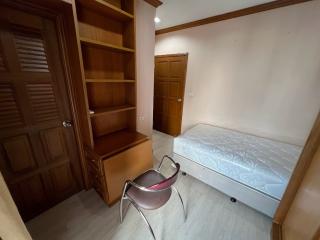 Cozy bedroom with built-in wooden wardrobe and single bed