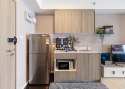 Modern kitchen with wood finishes and stainless steel appliances in a contemporary apartment