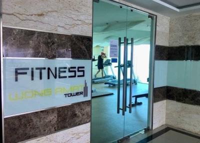 Fitness center entrance with reflection of workout area in Wong Amat Tower