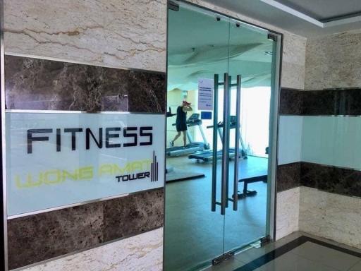 Fitness center entrance with reflection of workout area in Wong Amat Tower