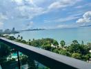 Scenic balcony view overlooking the ocean, greenery, and city skyline