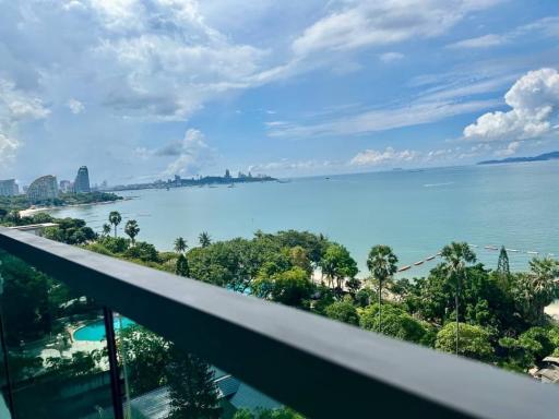 Scenic balcony view overlooking the ocean, greenery, and city skyline