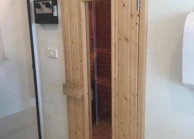 Wooden door leading to sauna adjacent to bathroom area