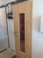 Wooden door leading to sauna adjacent to bathroom area