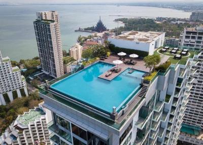 Aerial view of a modern high-rise building with rooftop pool