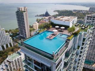 Aerial view of a modern high-rise building with rooftop pool