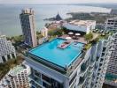 Aerial view of a modern high-rise building with rooftop pool