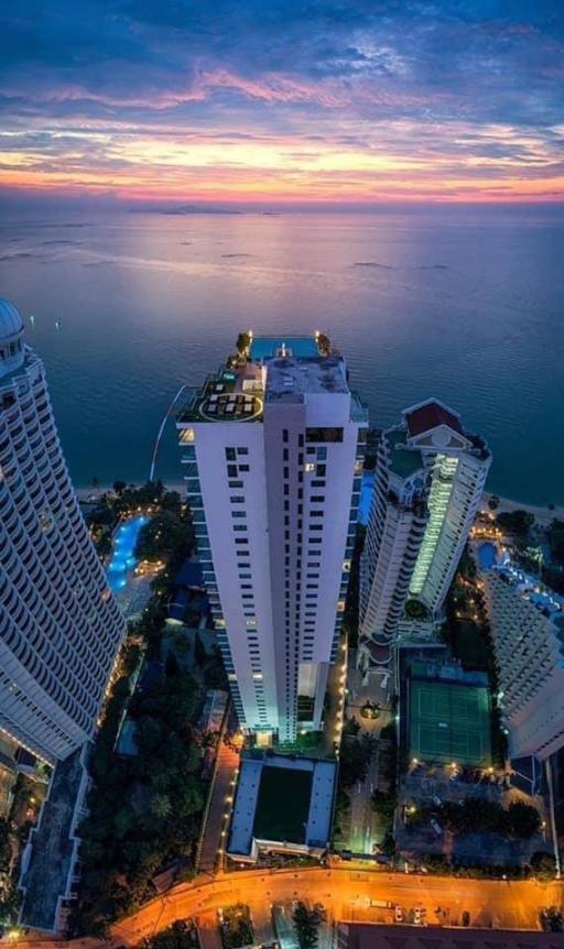 High-rise residential buildings by the seaside at twilight with vibrant sunset