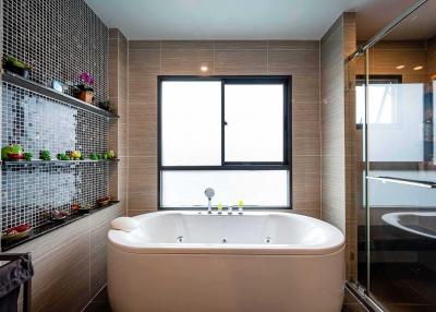 Modern bathroom interior with a large window, bathtub, and elegant tiling