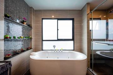 Modern bathroom interior with a large window, bathtub, and elegant tiling