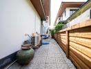 Paved side yard of a residential building with a wooden fence