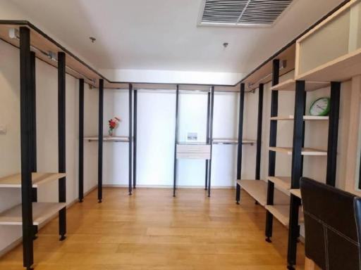 Spacious unfurnished office space with wooden flooring and shelf units