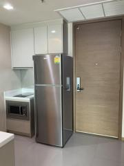 Modern kitchen with stainless steel refrigerator and built-in microwave