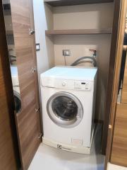 Modern built-in laundry machine in a wooden cabinet