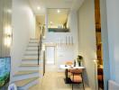 Modern interior design of a well-lit duplex with dining area and staircase
