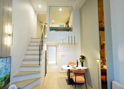 Modern interior design of a well-lit duplex with dining area and staircase