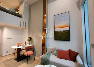 Modern apartment interior with open floor plan, featuring a cozy living space, dining area, and elegant vertical lighting