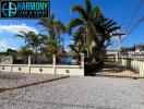 Spacious outdoor area with lush landscaping and gated entrance