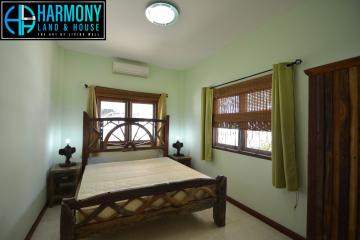 Cozy bedroom with wooden bed frame and green curtains