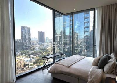 Modern bedroom with floor-to-ceiling windows overlooking the city