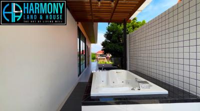 Modern outdoor Jacuzzi with a wooden ceiling and privacy wall