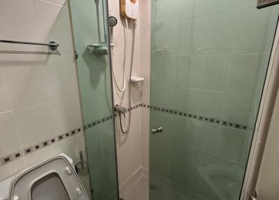 Compact bathroom with glass shower enclosure and white fixtures