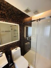 Modern bathroom with glass shower and mosaic tile walls