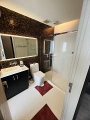 Modern bathroom with dark tiles and glass shower