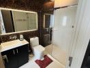Modern bathroom with dark tiles and glass shower