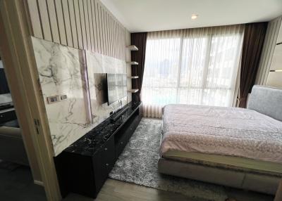 Modern bedroom with large bed and entertainment unit