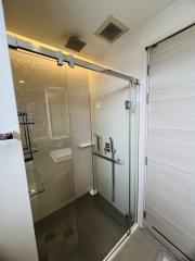 Modern bathroom with glass shower enclosure and neutral tiles