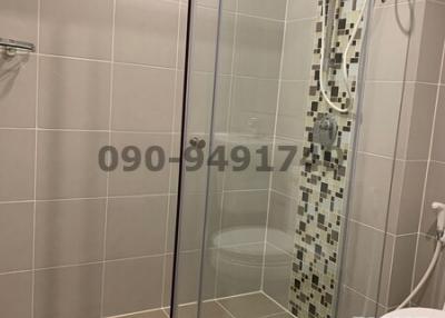 Modern bathroom with glass shower enclosure and tiled walls