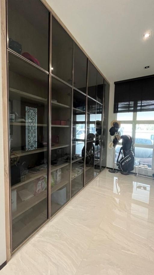 Spacious bedroom with large mirrored closet and glossy tiled flooring