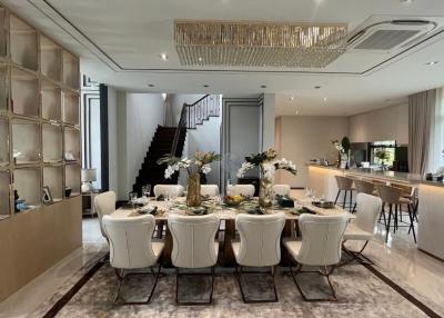 Elegant dining room with modern decor and adjacent kitchen