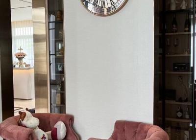 Elegant living room with large decorative wall clock and stylish armchairs