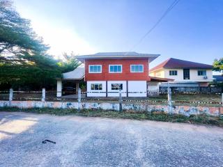 Spacious two-story house with a red and white facade and clear blue sky