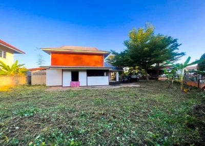 Spacious detached house with orange roof, large front yard, and a clear sky