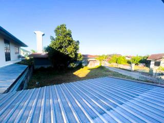 Spacious back yard with large tree and metal roofed structure