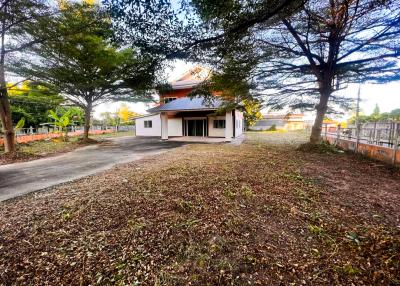 Single-family home surrounded by trees with a large front yard