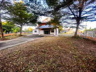 Single-family home surrounded by trees with a large front yard