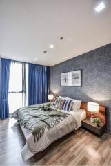 Cozy modern bedroom with king-sized bed, blue curtains, and hardwood flooring