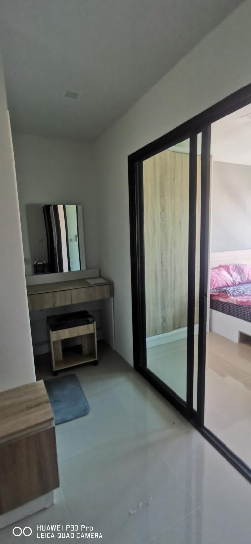 Modern bedroom with large mirror and en-suite entrance
