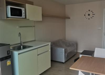 Compact studio apartment with kitchenette, bed, and dining area